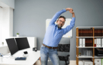 A person stretching at their work from home setup desk